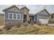 Charming two-story home featuring a blue facade with stone accents and a well-manicured front yard at 12650 W Big Horn Cir, Broomfield, CO 80021