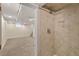 Modern bathroom shower stall with neutral tiling and a peek into an unfurnished basement at 3332 N Vine St, Denver, CO 80205