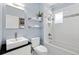 Well-lit bathroom features white tiled shower/tub, modern sink and floating shelves at 3332 N Vine St, Denver, CO 80205