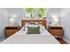 Cozy bedroom features a wood headboard, side tables with lamps, and a bright window view at 3332 N Vine St, Denver, CO 80205