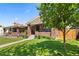 Brick home with manicured lawn, sidewalk, and mature tree providing shade in the front yard at 3332 N Vine St, Denver, CO 80205