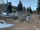 Wide exterior view of the home and RV set amongst a hillside forest landscape at 1805 Hidden Valley Rd, Sedalia, CO 80135