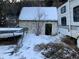 Stone outbuilding with a snow-covered roof and green door at 1805 Hidden Valley Rd, Sedalia, CO 80135