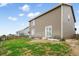 Spacious backyard features lawn, metal garden beds, partial fencing, and access to the house at 47312 Lilac Ave, Bennett, CO 80102