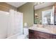Bathroom featuring a shower-tub combo, granite vanity, and an olive green accent wall at 47312 Lilac Ave, Bennett, CO 80102