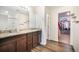 Bathroom featuring a double vanity with granite counters and a view into the walk in closet at 47312 Lilac Ave, Bennett, CO 80102