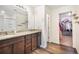 Bathroom showcasing double sinks with granite counters, wood-look floors, and a walk-in closet at 47312 Lilac Ave, Bennett, CO 80102