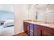 Bathroom highlighting double sinks, granite counters, wood-look floors and a view of the bedroom at 47312 Lilac Ave, Bennett, CO 80102