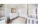 Bright bedroom featuring a white dresser, modern mirror, neutral carpet, and closet with sliding doors at 47312 Lilac Ave, Bennett, CO 80102