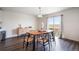 Open dining area with hardwood floors, a dining table, and a sliding glass door at 47312 Lilac Ave, Bennett, CO 80102
