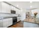 Modern kitchen with stainless steel appliances, granite countertops, and white cabinetry at 47312 Lilac Ave, Bennett, CO 80102