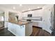 Kitchen with island, stainless appliances, white cabinetry, and hardwood floors at 47312 Lilac Ave, Bennett, CO 80102