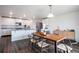 Bright kitchen and dining area with stainless appliances, white cabinetry, and wood table at 47312 Lilac Ave, Bennett, CO 80102