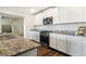 Spacious kitchen with white cabinetry, granite countertops, and stainless steel appliances at 47312 Lilac Ave, Bennett, CO 80102