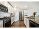 Well-equipped kitchen featuring granite countertops, stainless steel appliances, and white cabinets at 47312 Lilac Ave, Bennett, CO 80102