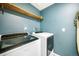 Updated laundry room with side-by-side washer and dryer plus light wood shelf at 47312 Lilac Ave, Bennett, CO 80102