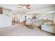 Spacious living room with plush carpeting, a ceiling fan, and open access to the kitchen at 47312 Lilac Ave, Bennett, CO 80102