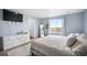 Calm main bedroom with a TV, sleek dresser, and a full length mirror by a bright window at 47312 Lilac Ave, Bennett, CO 80102