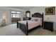 Comfortable bedroom featuring balcony access, neutral carpet, and stylish black furniture at 7000 E Quincy Ave # 302, Denver, CO 80237