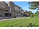 Attractive condo building featuring well-maintained lawn, mature trees, and inviting exterior elevation at 7000 E Quincy Ave # 302, Denver, CO 80237