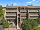 Multi-story condo building with private patios, lush trees, and convenient stairway access at 7000 E Quincy Ave # 302, Denver, CO 80237