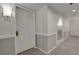Well-lit hallway with neutral tones, wainscoting, and unit number for a welcoming entrance at 7000 E Quincy Ave # 302, Denver, CO 80237