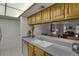 This kitchen features wooden cabinetry, light countertops, white appliances, and a breakfast bar that opens up to the dining area at 7000 E Quincy Ave # 302, Denver, CO 80237