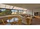 Bright living room with a glass table and wicker furniture is filled with natural light from large windows at 7000 E Quincy Ave # 302, Denver, CO 80237