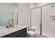 Modern bathroom featuring a glass-enclosed shower, vanity with quartz countertop, and a tile floor at 747 Raindance St, Erie, CO 80516