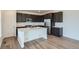 Modern kitchen featuring dark cabinets, stainless steel appliances, and a center island with a quartz countertop at 747 Raindance St, Erie, CO 80516