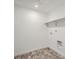 White laundry room with tile floors and shelf at 747 Raindance St, Erie, CO 80516