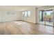 Bright living room with light wood floors, three large windows, and sliding doors to a patio at 747 Raindance St, Erie, CO 80516