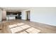 Open-concept living room with light wood floors, a large window, and a view into the adjacent kitchen at 747 Raindance St, Erie, CO 80516