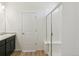 Bright bathroom features a glass-enclosed shower, single sink vanity, and white door at 9332 Bahama Ct, Commerce City, CO 80022