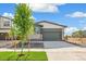 Charming home with a grey garage door, brick and hardiplank siding, and a young tree in the front yard at 9332 Bahama Ct, Commerce City, CO 80022