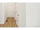 Bright hallway featuring wood-look flooring and white doors, offering a clean and modern feel at 9332 Bahama Ct, Commerce City, CO 80022