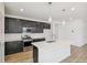 Modern kitchen with dark cabinets, a white countertop island, and stainless steel appliances, perfect for cooking at 9332 Bahama Ct, Commerce City, CO 80022