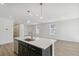Spacious living room with light wood flooring and adjacent open concept kitchen at 9332 Bahama Ct, Commerce City, CO 80022
