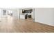 Spacious living area showcasing wood-look floors, a kitchen with an island, and access to the outdoors at 9332 Bahama Ct, Commerce City, CO 80022
