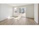 Bright living space featuring wood-look floors and a sliding glass door, offering seamless indoor-outdoor living at 9332 Bahama Ct, Commerce City, CO 80022