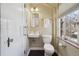 Bright bathroom featuring a wall sink, classic tile and a large window with exterior views at 629 Bellaire St, Denver, CO 80220