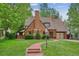 Charming brick Tudor-style home featuring a lush lawn and a welcoming stone walkway at 629 Bellaire St, Denver, CO 80220