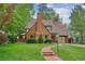 Charming brick Tudor-style home featuring a lush lawn and a welcoming stone walkway at 629 Bellaire St, Denver, CO 80220