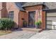 Close up of the front door with black iron security screen and manicured landscaping at 629 Bellaire St, Denver, CO 80220