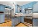 Modern kitchen with stainless steel appliances, granite countertops, and blue cabinets at 629 Bellaire St, Denver, CO 80220