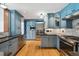 Modern kitchen featuring custom blue cabinets, stainless steel appliances, granite countertops and hardwood flooring at 629 Bellaire St, Denver, CO 80220