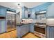 Contemporary kitchen with blue cabinets, stainless steel appliances, granite countertops, and hardwood flooring at 629 Bellaire St, Denver, CO 80220