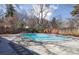 Backyard pool is surrounded by mature trees and a wooden fence at 629 Bellaire St, Denver, CO 80220