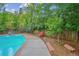 A backyard pool with lounge chairs and surrounded by a wooden fence and mature trees at 629 Bellaire St, Denver, CO 80220