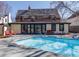 Backyard pool and outdoor living area of brick two-story home with full wall of glass doors at 629 Bellaire St, Denver, CO 80220